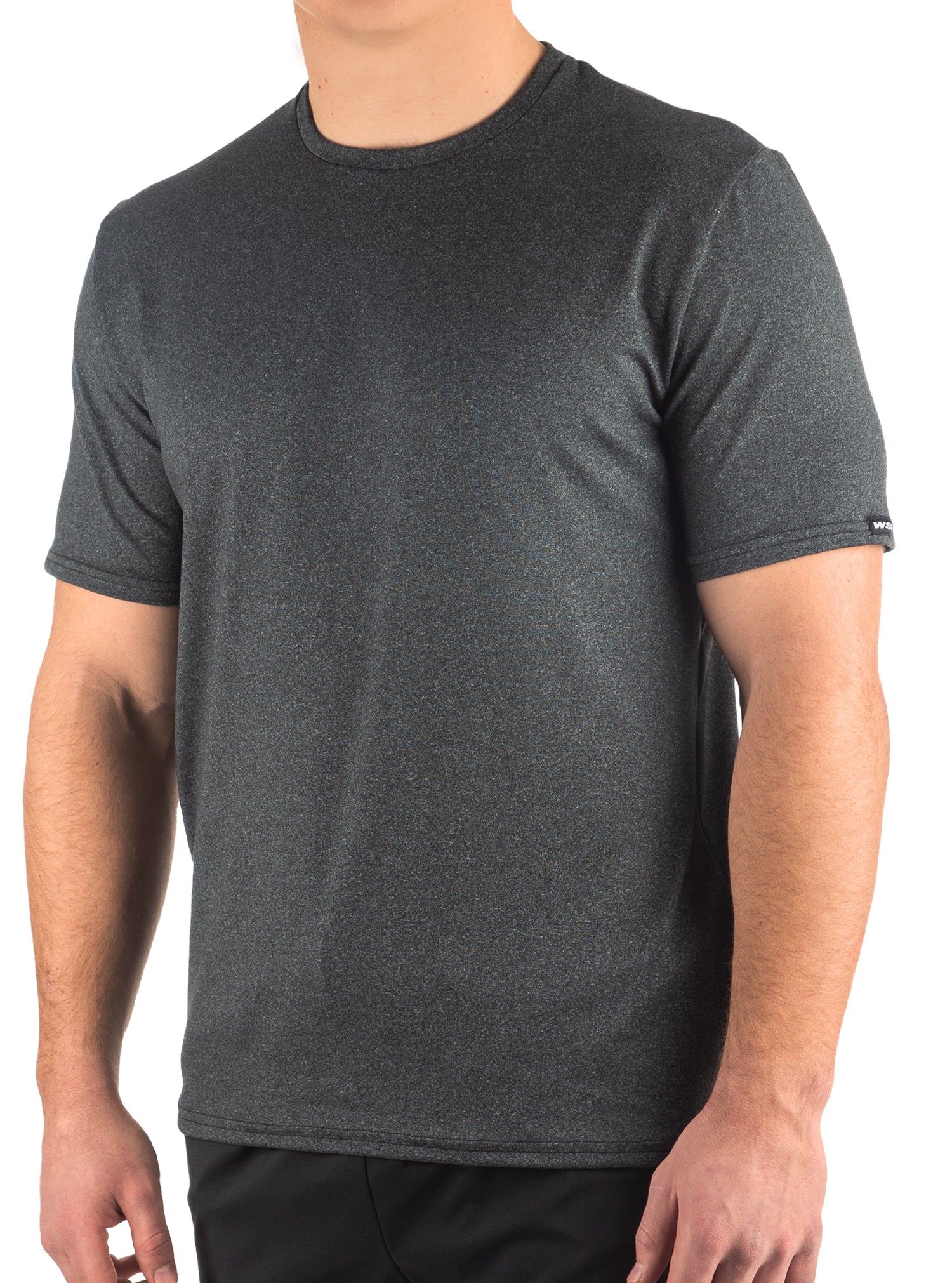 A man wearing a short sleeve T-shirt in a warehouse setting, with the sleeves rolled up to his elbows.